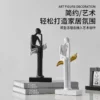 abstract reading sculptures – black & white duo seated on elegant leaves