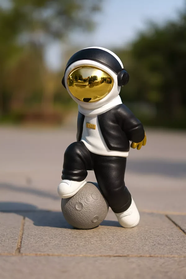 casual astronaut sculpture – black & white design with gold helmet on planet base casual astronaut sculpture – black & white design with gold helmet on planet base