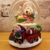 christmas snow globe – santa & child with gift train and whimsical winter charm