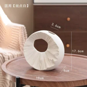 speckled white circular sculpture vase